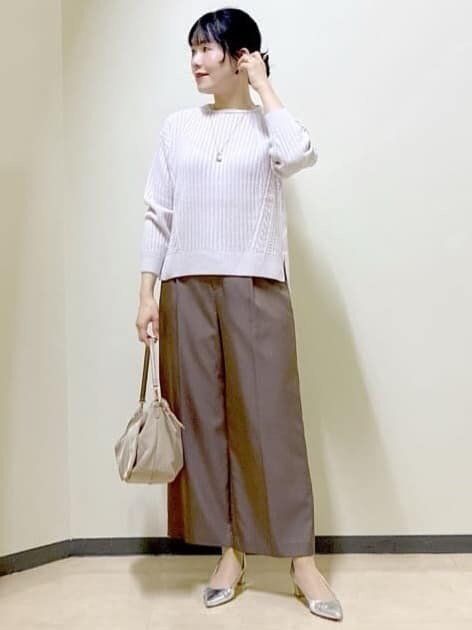 グレー系のニット/セーター、ブラウン系のその他パンツ、ベージュ系のショルダーバッグを着用したレディースの冬コーディネートの2枚目の写真