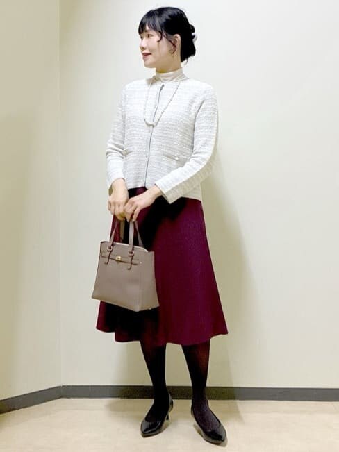 グレー系のカーディガン/ボレロ、ベージュ系のニット/セーター、レッド系のスカートを着用したレディースの冬コーディネートの5枚目の写真
