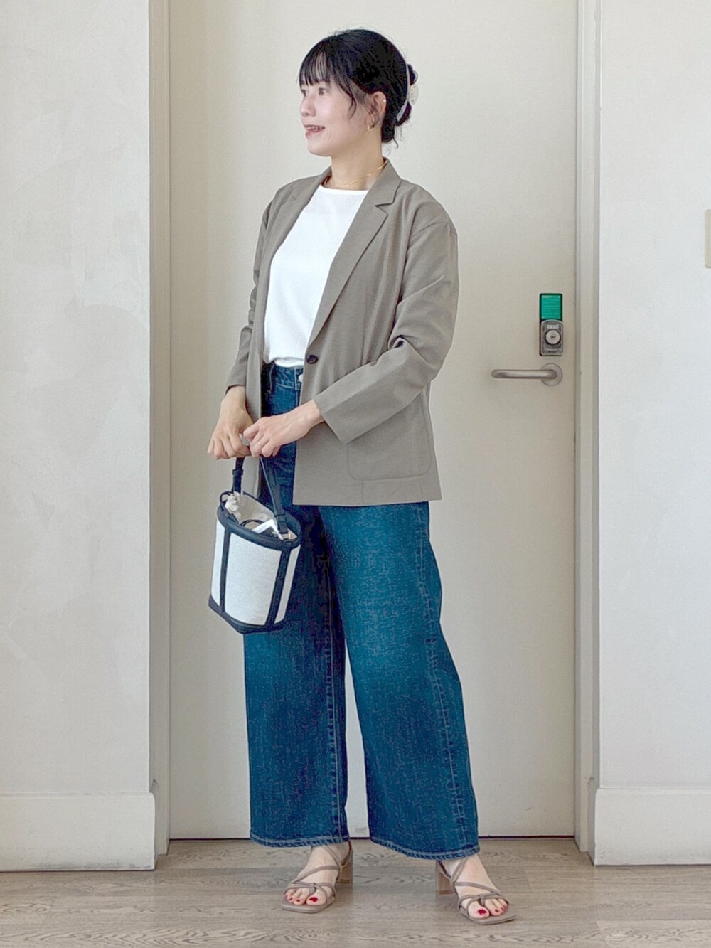 グリーン系のテーラードジャケット、ホワイト系のTシャツ/カットソー、ブルー系のデニムパンツを着用したレディースの夏コーディネートの7枚目の写真