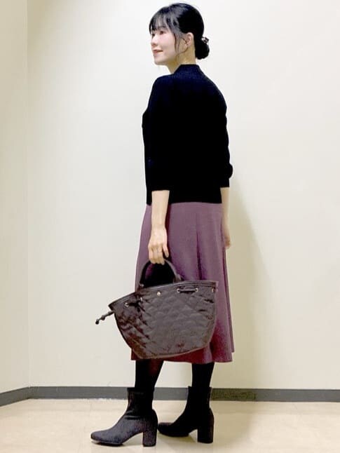ブラック系のニット/セーター、レッド系のスカート、ブラウン系のカーディガン/ボレロを着用したレディースの秋コーディネートの4枚目の写真