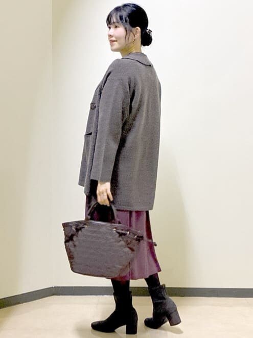 ブラウン系のカーディガン/ボレロ、ブラック系のニット/セーター、レッド系のスカートを着用したレディースの冬コーディネートの4枚目の写真