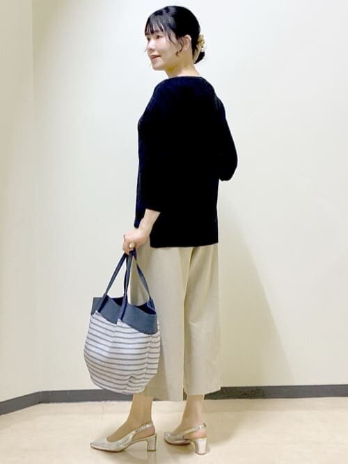 ベージュ系のその他パンツ、ブラック系のニット/セーター、ブルー系のトートバッグを着用したレディースの春コーディネートの4枚目の写真
