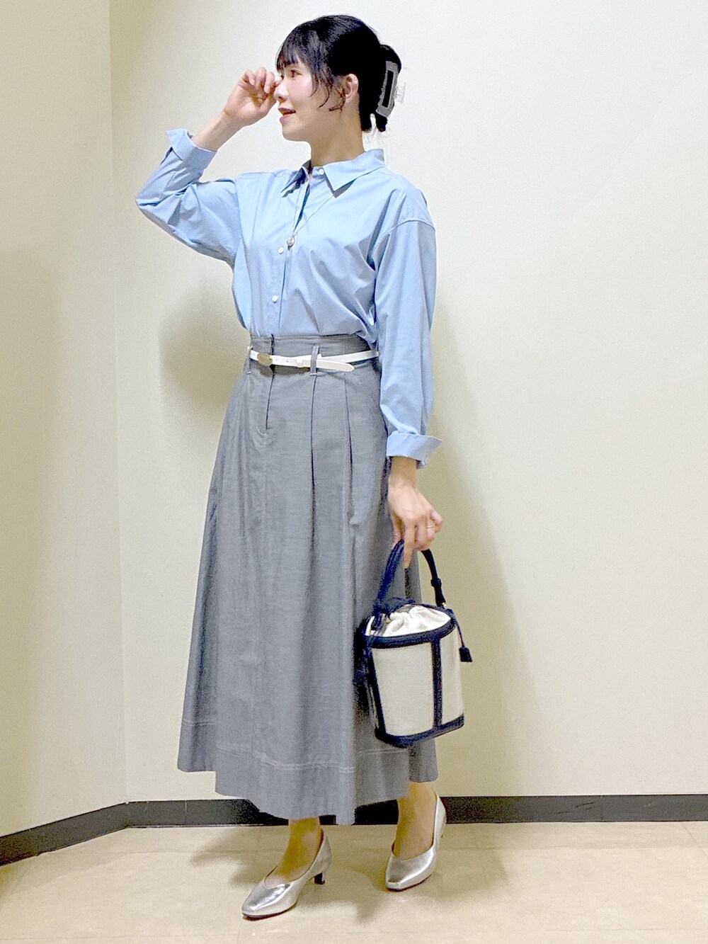 ブルー系のシャツ/ブラウス、ブルー系のニット/セーター、ブラック系のスカートを着用したレディースの春コーディネートの5枚目の写真