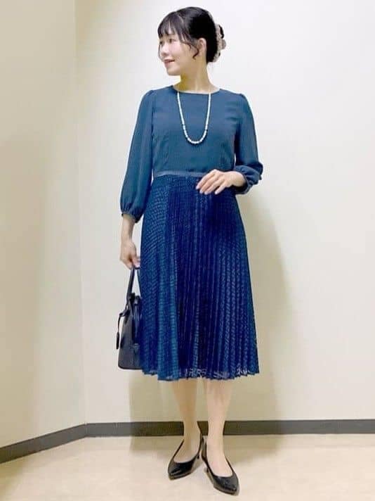 ブルー系のワンピース、ブルー系のトレンチコート、ブルー系のハンドバッグを着用したレディースの冬コーディネートの5枚目の写真