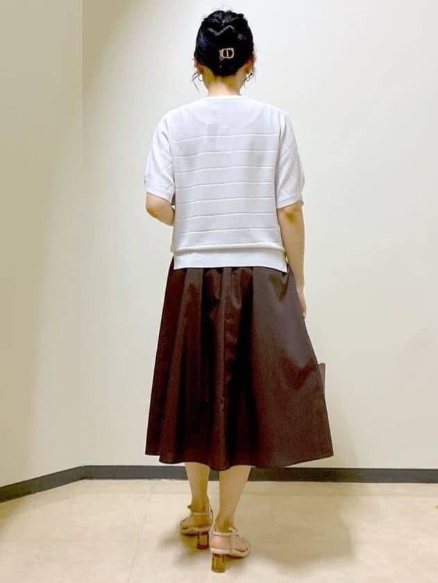 グレー系のニット/セーター、ブラウン系のスカート、ブラック系のニット/セーターを着用したレディースの夏コーディネートの3枚目の写真
