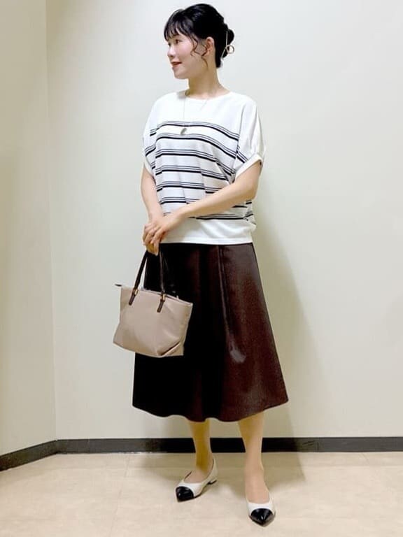 ホワイト系のニット/セーター、グレー系のその他パンツ、ブラウン系のスカートを着用したレディースの夏コーディネートの10枚目の写真