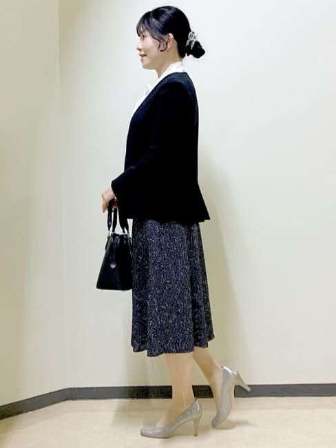 ブラック系のノーカラージャケット、ホワイト系のシャツ/ブラウス、ブラック系のスカートを着用したレディースの冬コーディネートの2枚目の写真