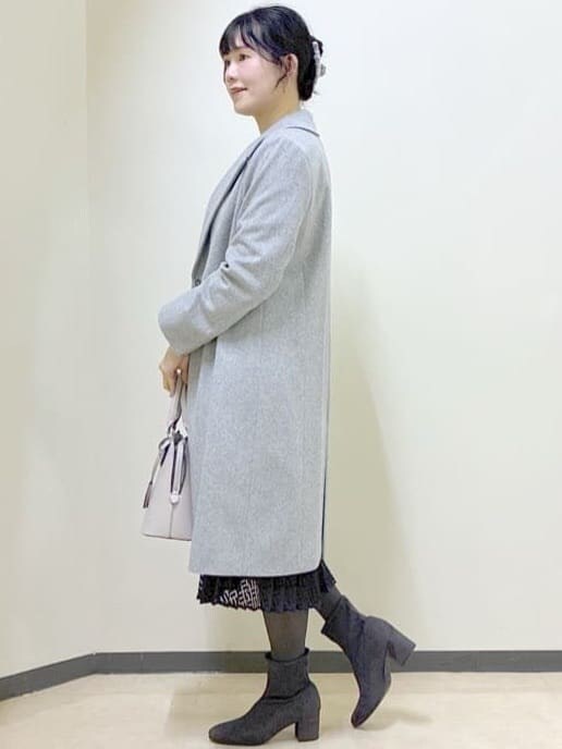 ブルー系のワンピース、グレー系のチェスターコート、ベージュ系のハンドバッグを着用したレディースの冬コーディネートの9枚目の写真