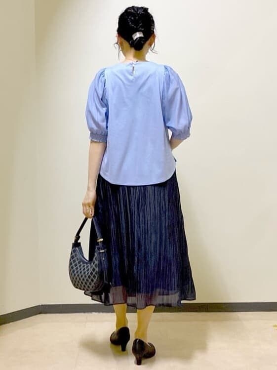 ブルー系のシャツ/ブラウス、ブラック系のスカート、ブルー系のショルダーバッグを着用したレディースの秋コーディネートの3枚目の写真