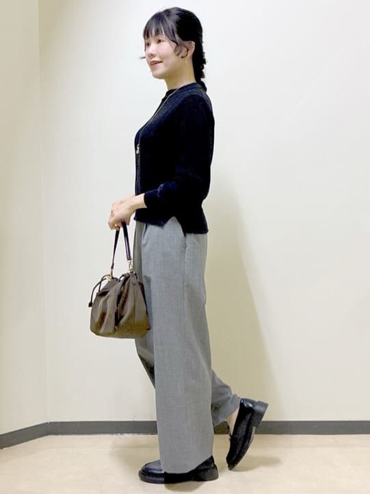 ブラック系のニット/セーター、グレー系のその他パンツ、ブラウン系のショルダーバッグを着用したレディースの冬コーディネートの2枚目の写真