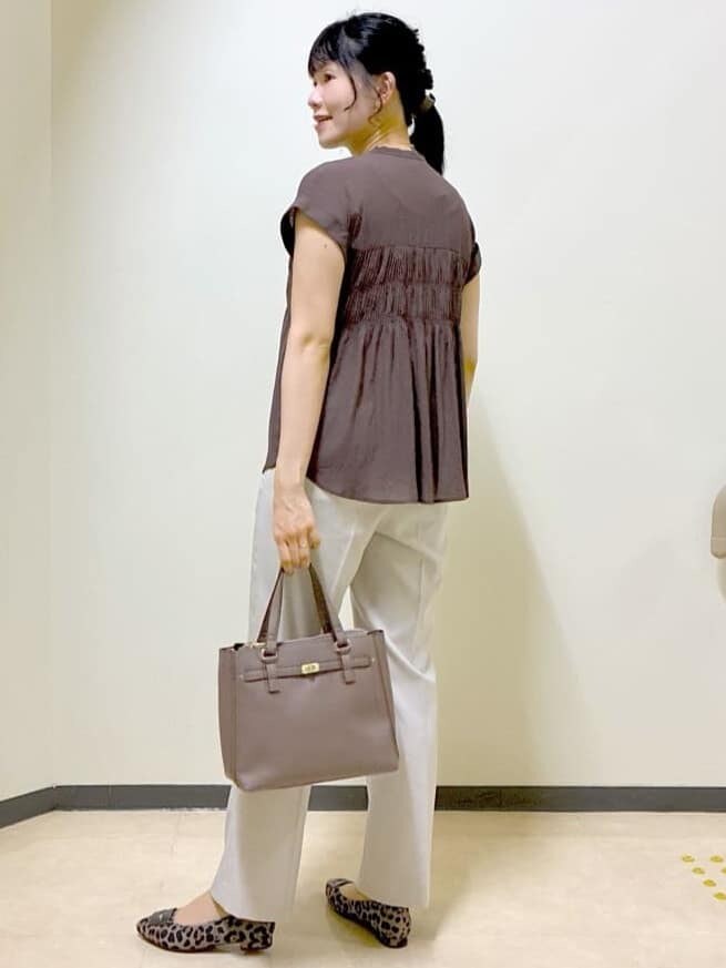 ブラウン系のシャツ/ブラウス、ベージュ系のその他パンツ、ブラウン系のハンドバッグを着用したレディースの秋コーディネートの4枚目の写真