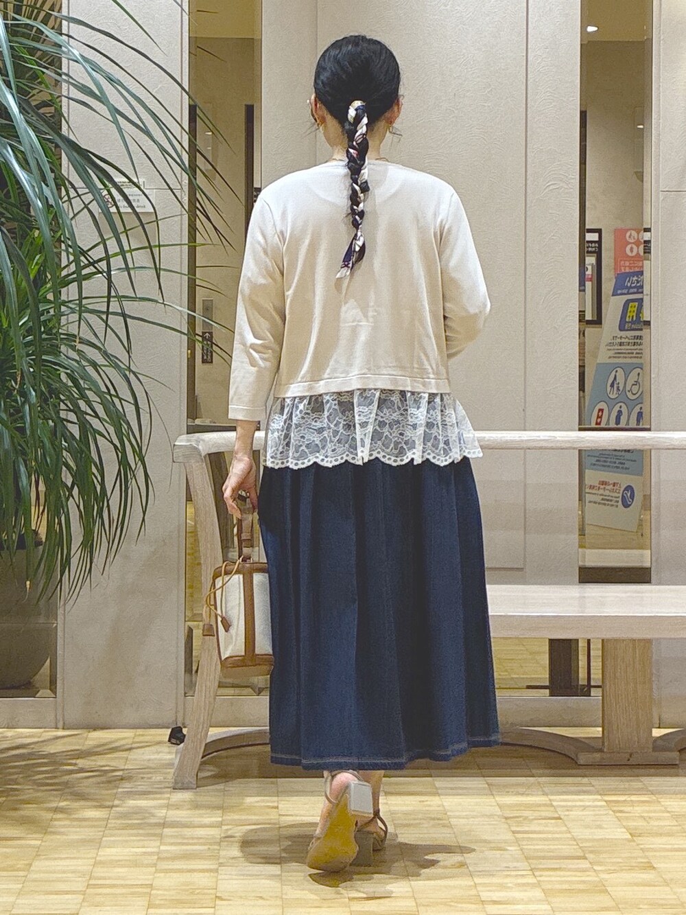グレー系のカーディガン/ボレロ、ホワイト系のTシャツ/カットソー、ブルー系のデニムスカートを着用したレディースの秋コーディネートの3枚目の写真