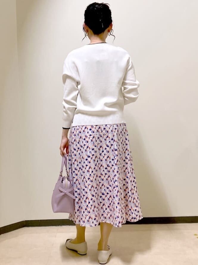 ホワイト系のニット/セーター、オレンジ系のスカート、ピンク系のデニムジャケットを着用したレディースの春コーディネートの3枚目の写真