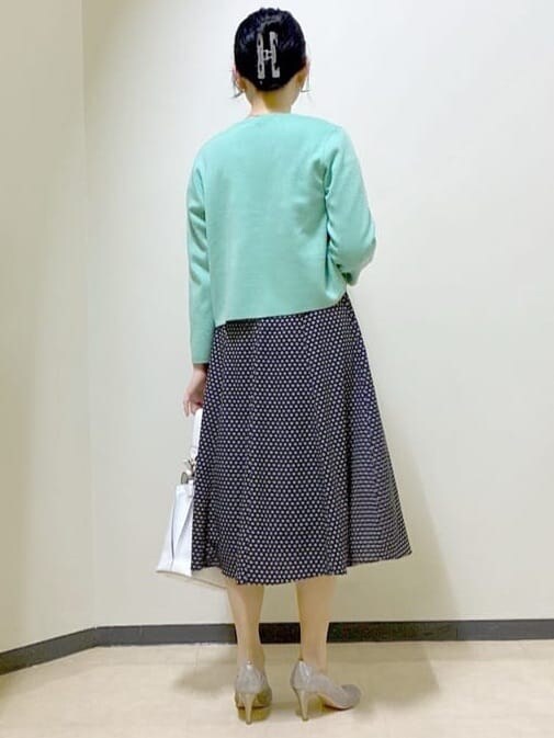 ベージュ系のワンピース、グリーン系のカーディガン/ボレロ、ホワイト系のトートバッグを着用したレディースの春コーディネートの3枚目の写真