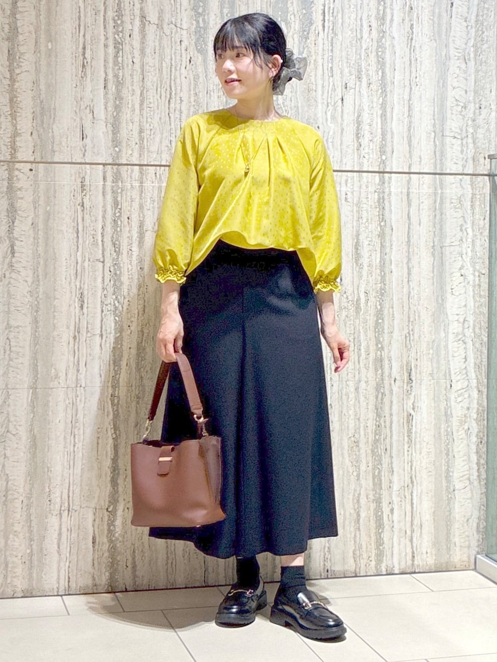 イエロー系のシャツ/ブラウス、ブルー系のその他パンツ、ブラウン系のトートバッグを着用したレディースの秋コーディネートの7枚目の写真