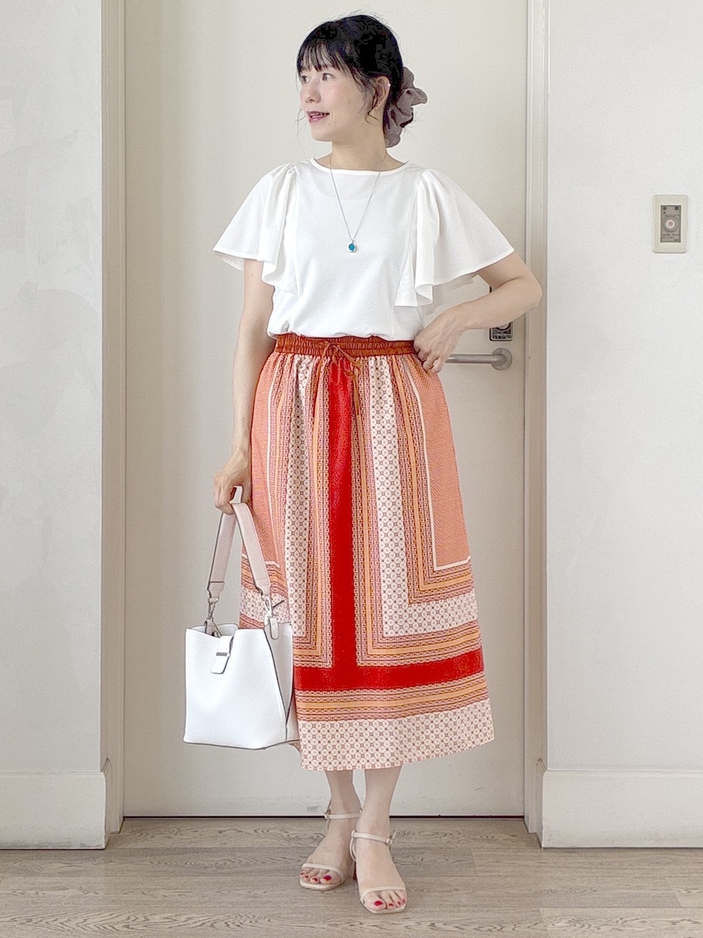 ホワイト系のTシャツ/カットソー、オレンジ系のスカート、ホワイト系のトートバッグを着用したレディースの夏コーディネートの9枚目の写真