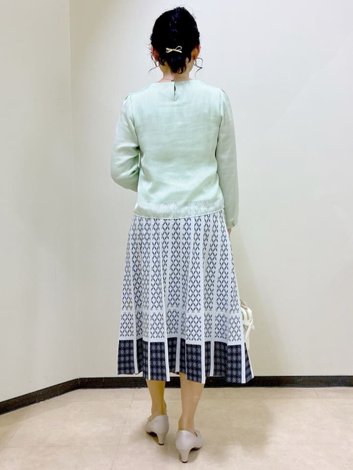 グリーン系のシャツ/ブラウス、ブルー系のカーディガン/ボレロ、ホワイト系のスカートを着用したレディースの春コーディネートの3枚目の写真