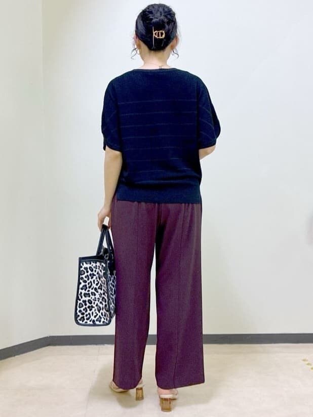 ブラック系のニット/セーター、ブラウン系のその他パンツ、ブラック系のトートバッグを着用したレディースの夏コーディネートの3枚目の写真