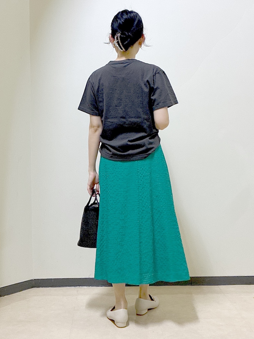 グレー系のTシャツ/カットソー、グリーン系のスカート、ベージュ系のノーカラージャケットを着用したレディースの春コーディネートの3枚目の写真