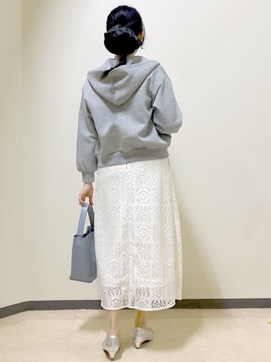 ホワイト系のスカート、グレー系のパーカー、シルバー系のパンプスを着用したレディースの春コーディネートの3枚目の写真