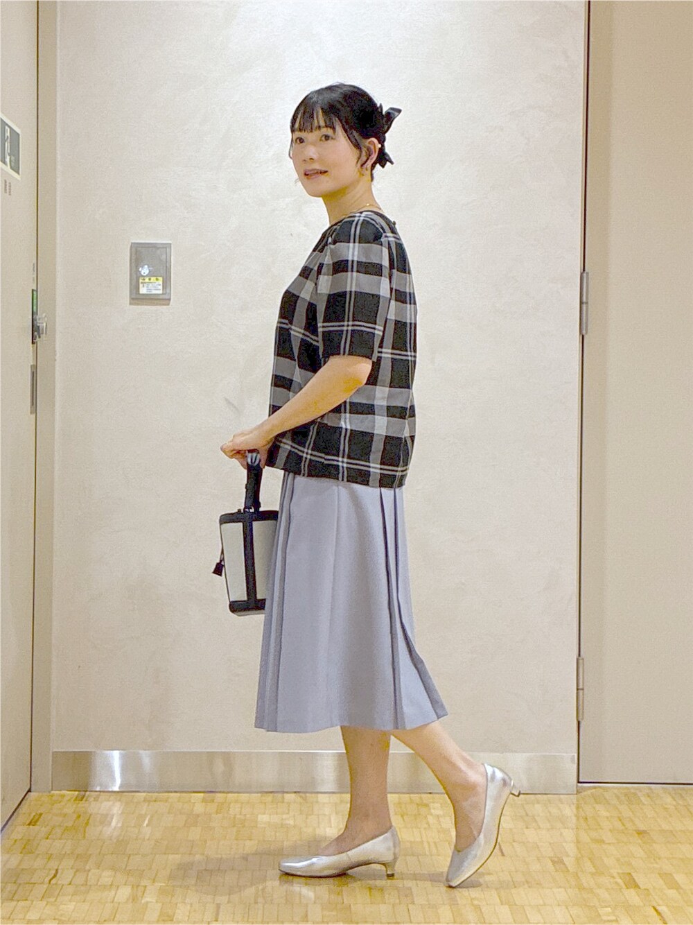 ブラック系のシャツ/ブラウス、ブルー系のスカート、ブルー系のブルゾンを着用したレディースの夏コーディネートの2枚目の写真