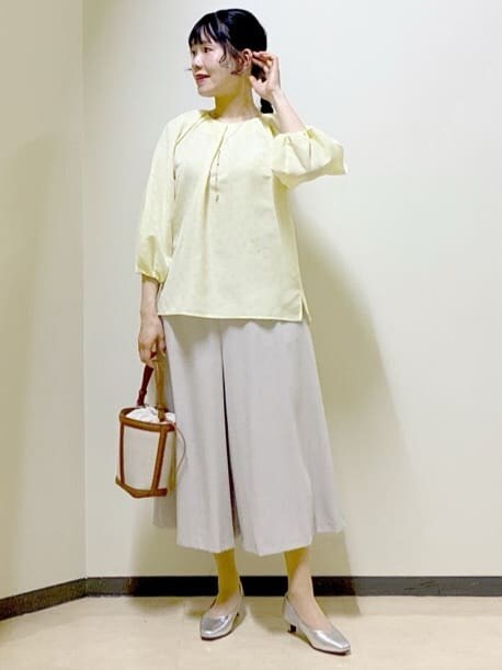 イエロー系のシャツ/ブラウス、シルバー系のパンプス、イエロー系のショルダーバッグを着用したレディースの春コーディネートの4枚目の写真