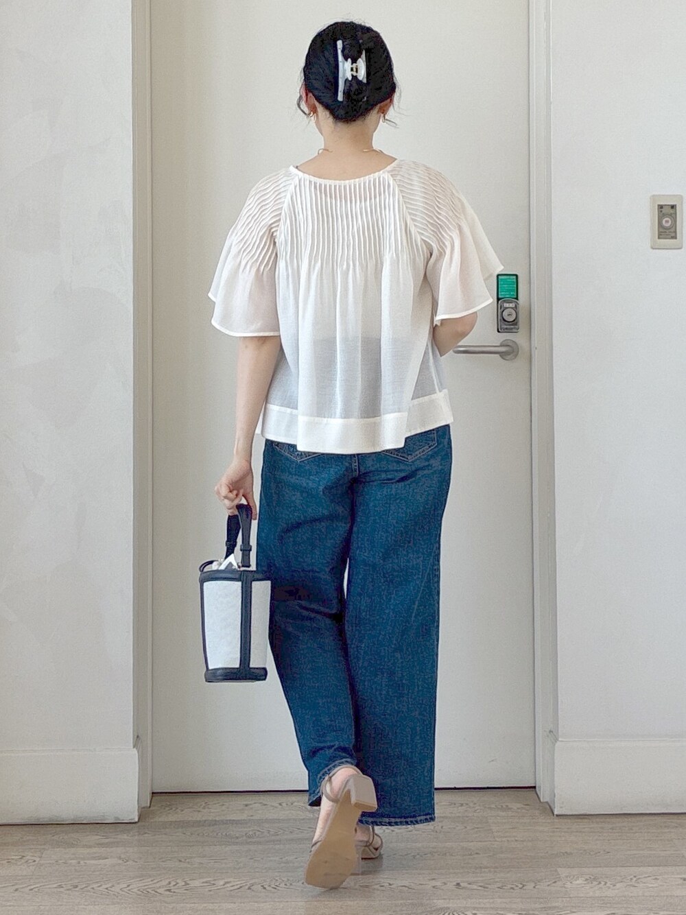 ホワイト系のシャツ/ブラウス、ベージュ系のタンクトップ、ブルー系のデニムパンツを着用したレディースの夏コーディネートの3枚目の写真