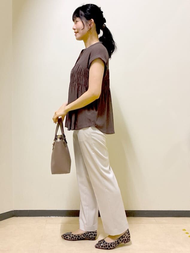 ブラウン系のシャツ/ブラウス、ベージュ系のその他パンツ、ブラウン系のハンドバッグを着用したレディースの秋コーディネートの2枚目の写真