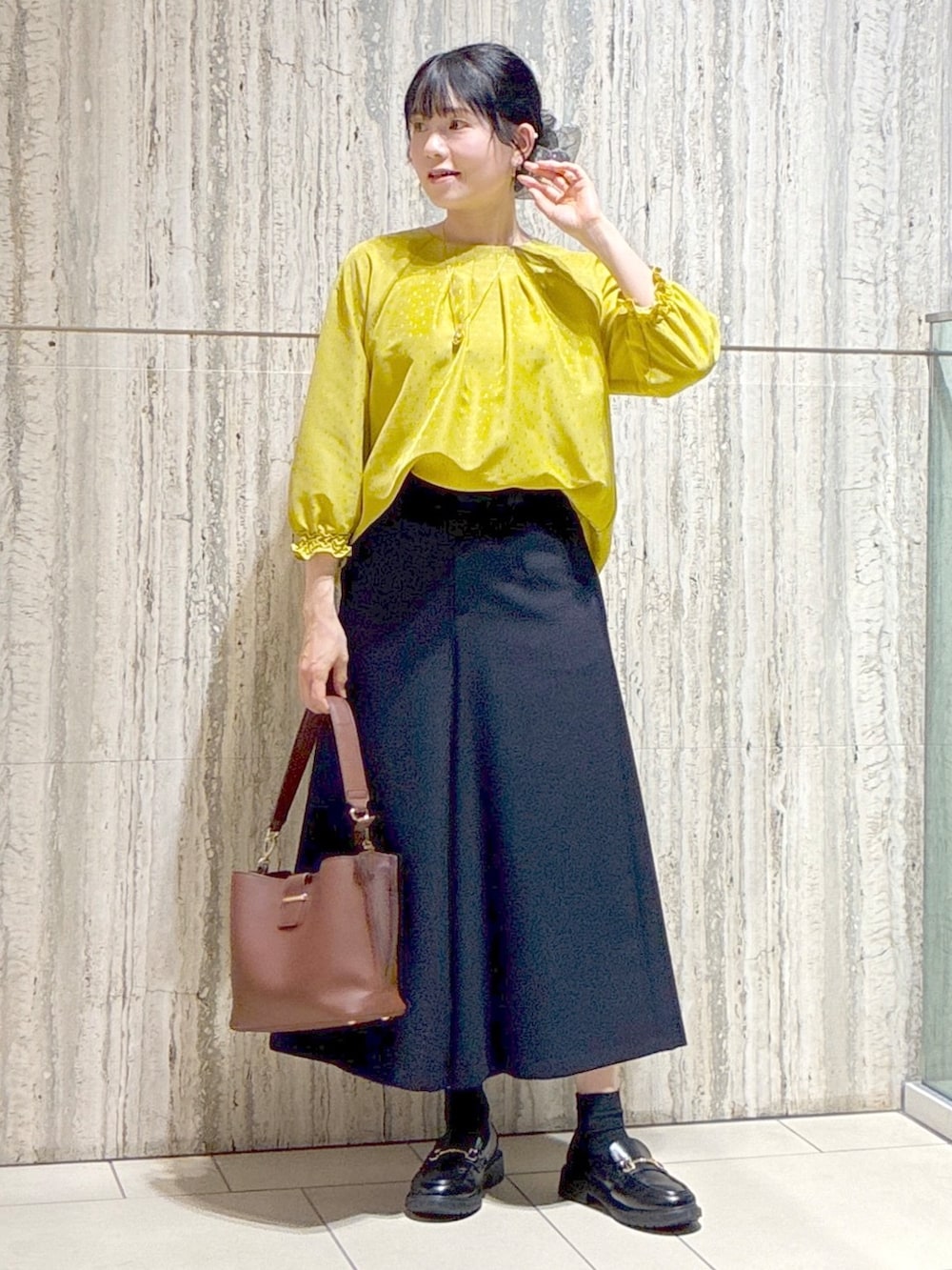 イエロー系のシャツ/ブラウス、ブルー系のその他パンツ、ブラウン系のトートバッグを着用したレディースの秋コーディネートの8枚目の写真