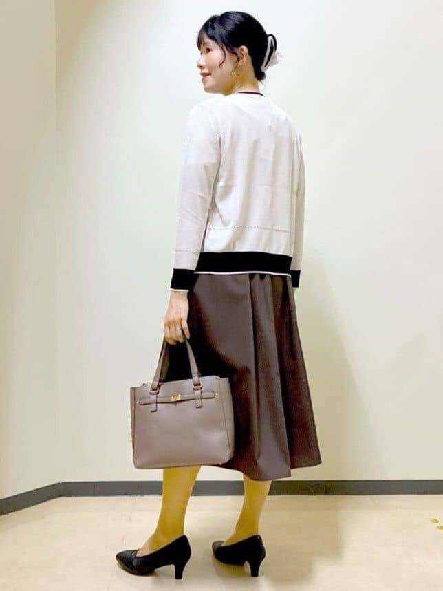 ベージュ系のカーディガン/ボレロ、ベージュ系のニット/セーター、ブラウン系のスカートを着用したレディースの夏コーディネートの5枚目の写真