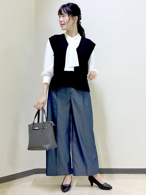 ホワイト系のシャツ/ブラウス、ブラック系のベスト、ブルー系のその他パンツを着用したレディースの秋コーディネートの9枚目の写真