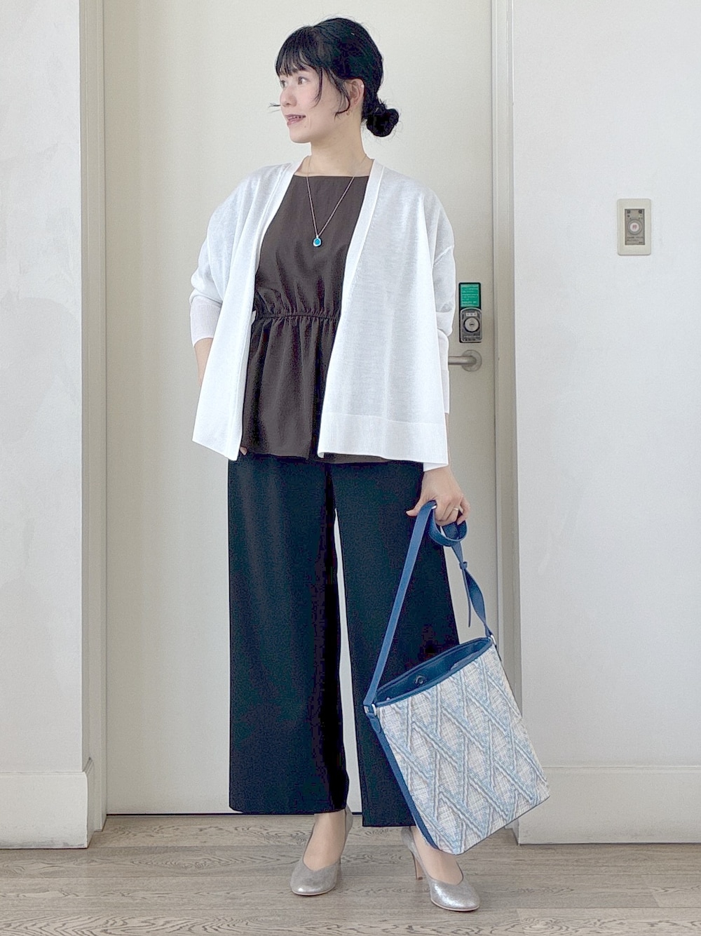 ブラック系のその他パンツ、ブルー系のショルダーバッグ、ホワイト系のカーディガン/ボレロを着用したレディースの春コーディネートの5枚目の写真
