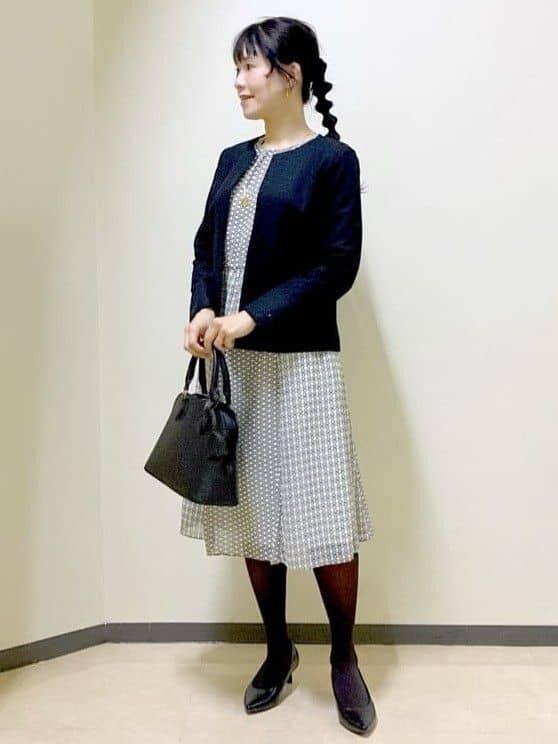 ブラック系のノーカラージャケット、ベージュ系のシャツ/ブラウス、ベージュ系のスカートを着用したレディースの冬コーディネートの6枚目の写真