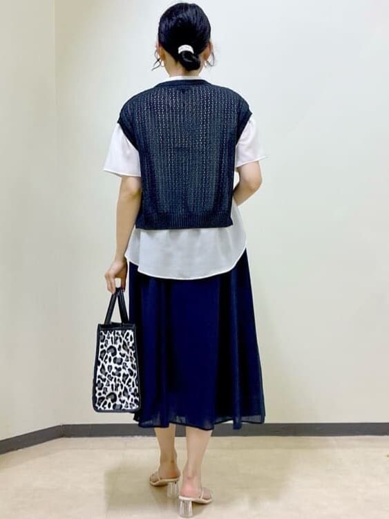 ベージュ系のシャツ/ブラウス、ブラック系のニット/セーター、ブルー系のスカートを着用したレディースの夏コーディネートの3枚目の写真