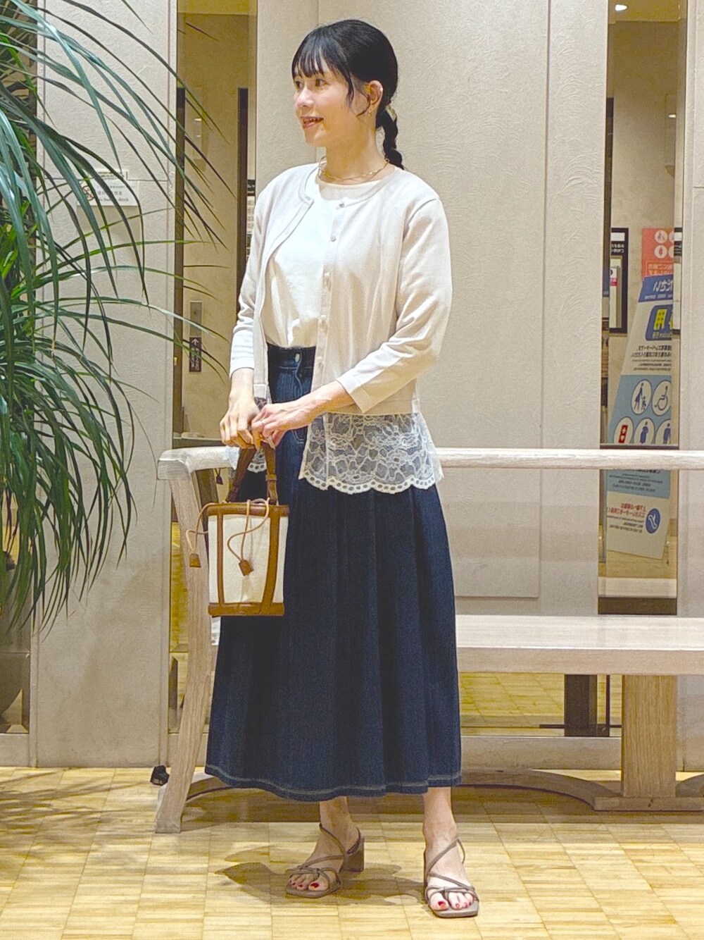 グレー系のカーディガン/ボレロ、ホワイト系のTシャツ/カットソー、ブルー系のデニムスカートを着用したレディースの秋コーディネートの6枚目の写真