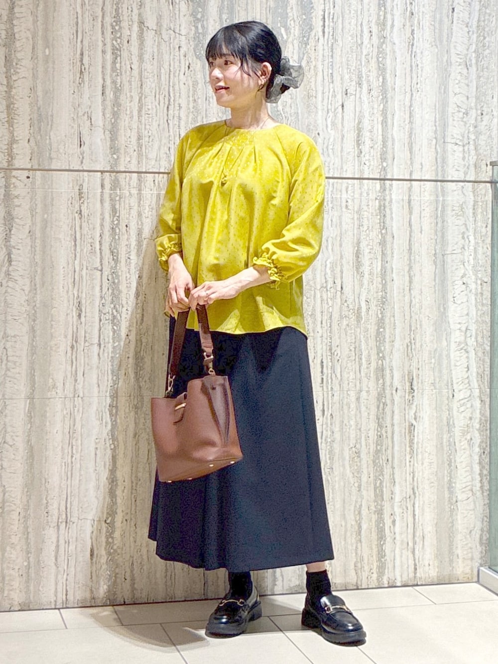 イエロー系のシャツ/ブラウス、ブルー系のその他パンツ、ブラウン系のトートバッグを着用したレディースの秋コーディネートの10枚目の写真