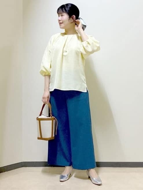 イエロー系のシャツ/ブラウス、シルバー系のパンプス、ブルー系のその他パンツを着用したレディースの冬コーディネートの6枚目の写真