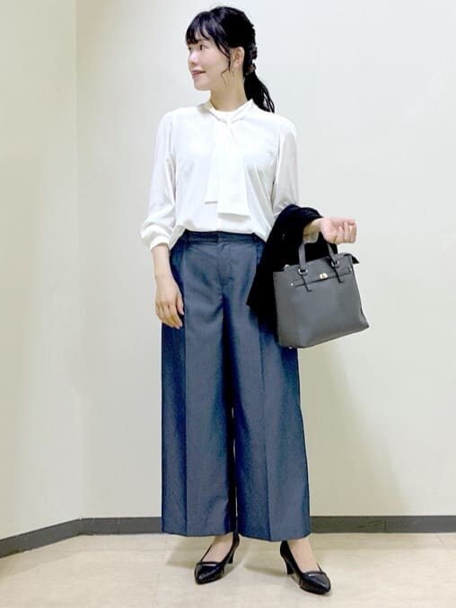 ホワイト系のシャツ/ブラウス、ブラック系のベスト、ブルー系のその他パンツを着用したレディースの秋コーディネートの7枚目の写真