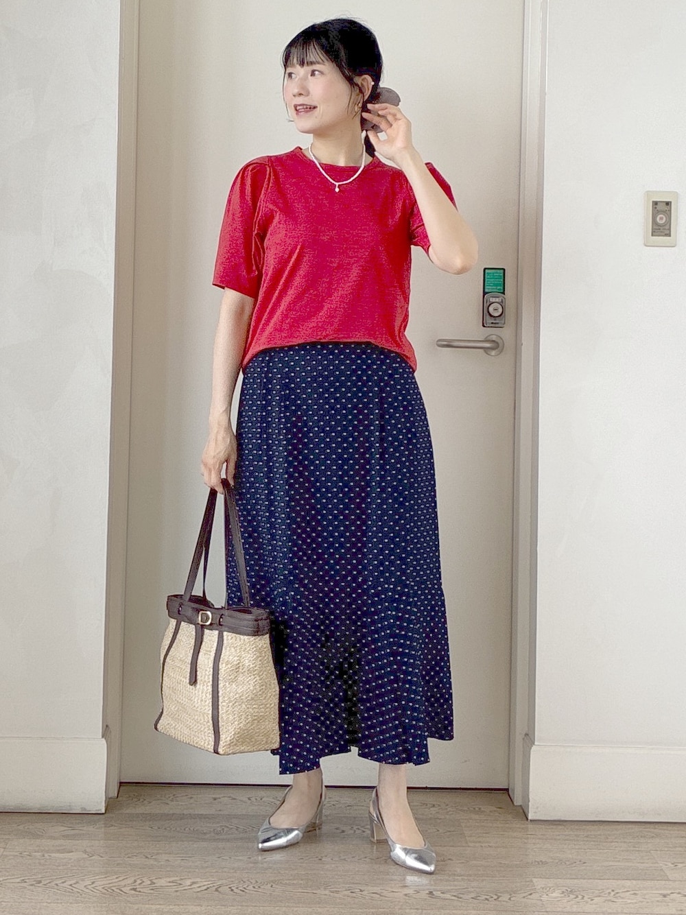 オレンジ系のTシャツ/カットソー、ブルー系のスカート、イエロー系のトートバッグを着用したレディースの夏コーディネートの6枚目の写真