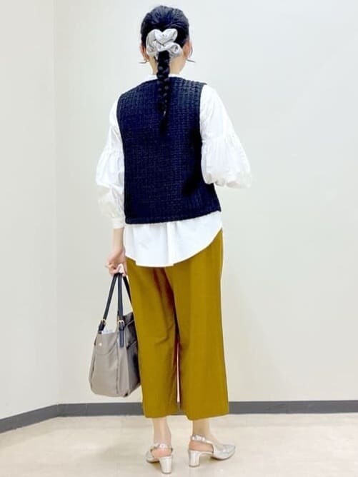 ブラック系のベスト、ホワイト系のシャツ/ブラウス、イエロー系のその他パンツを着用したレディースの春コーディネートの3枚目の写真