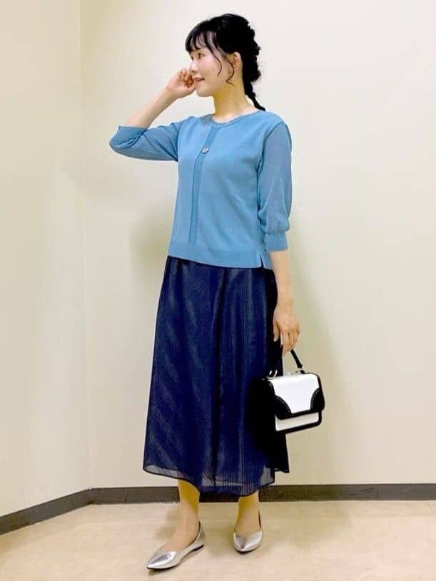 ブルー系のニット/セーター、ブルー系のスカート、ベージュ系のショルダーバッグを着用したレディースの夏コーディネートの6枚目の写真