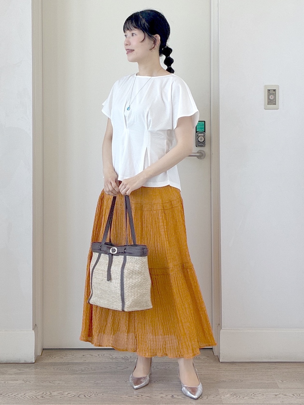 ホワイト系のTシャツ/カットソー、オレンジ系のスカート、イエロー系のトートバッグを着用したレディースの夏コーディネートの8枚目の写真