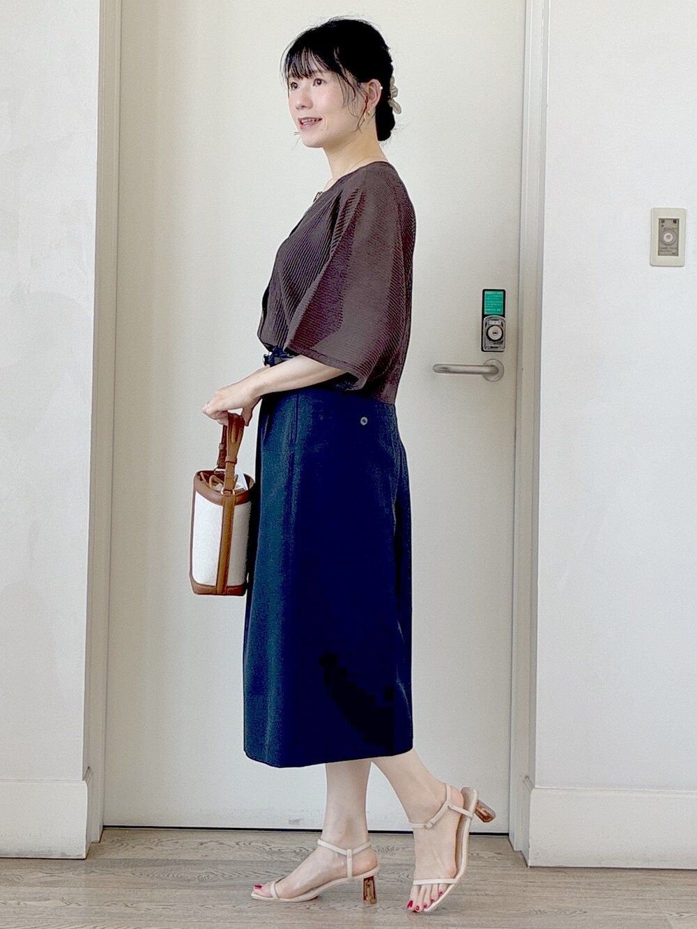 ブラウン系のニット/セーター、ブラック系のタンクトップ、ブルー系のその他パンツを着用したレディースの夏コーディネートの2枚目の写真