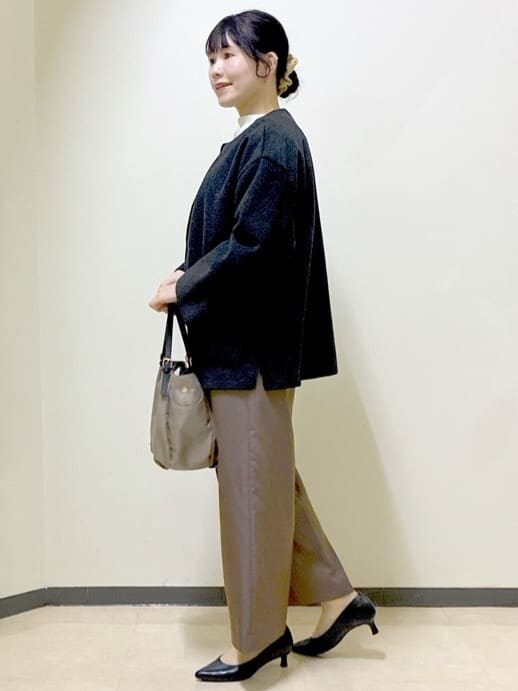 グレー系のノーカラーコート、ホワイト系のニット/セーター、ブラウン系のその他パンツを着用したレディースの冬コーディネートの2枚目の写真