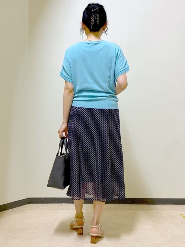 ブルー系のニット/セーター、ブルー系のスカート、ブルー系のスカートを着用したレディースの夏コーディネートの3枚目の写真