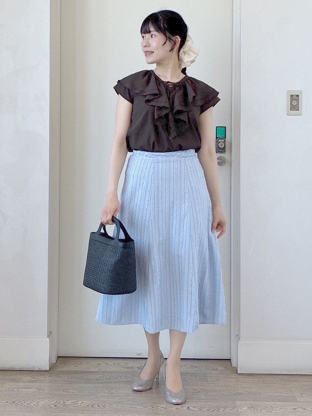 ブラウン系のシャツ/ブラウス、ブルー系のスカート、ベージュ系のタンクトップを着用したレディースの春コーディネートの5枚目の写真