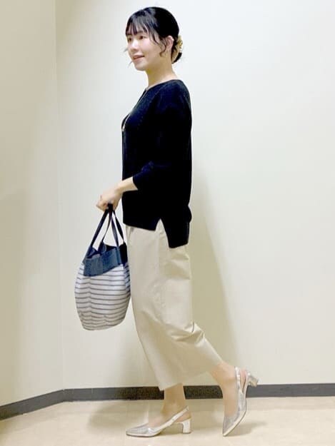 ベージュ系のその他パンツ、ブラック系のニット/セーター、ブルー系のトートバッグを着用したレディースの春コーディネートの2枚目の写真