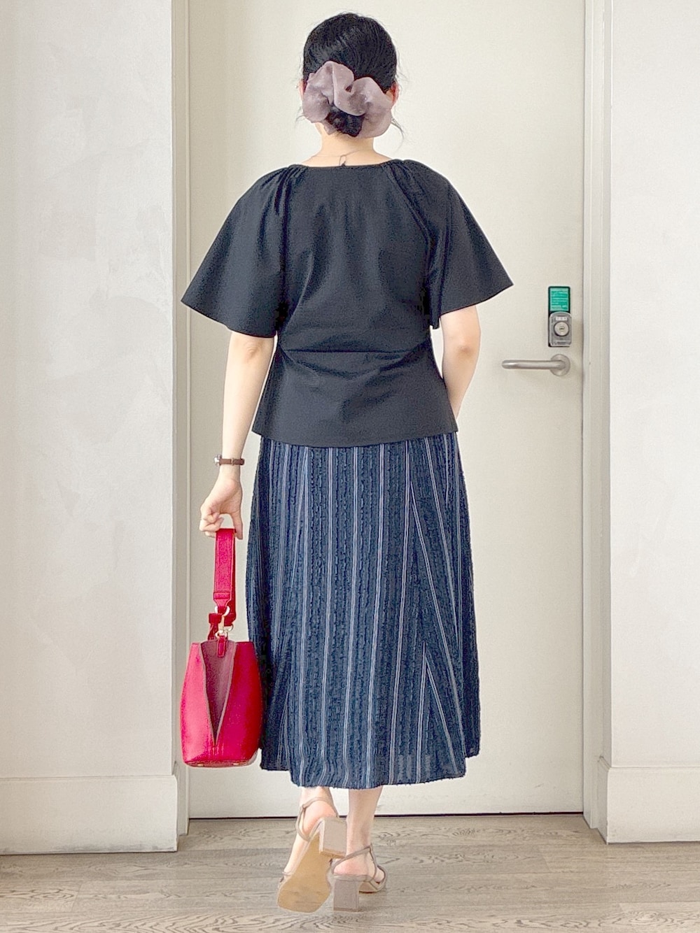 ブラック系のTシャツ/カットソー、ブルー系のスカート、レッド系のトートバッグを着用したレディースの夏コーディネートの3枚目の写真