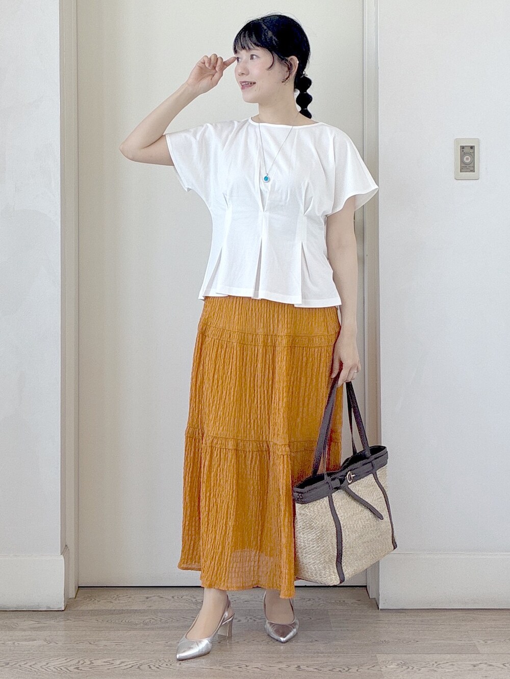 ホワイト系のTシャツ/カットソー、オレンジ系のスカート、イエロー系のトートバッグを着用したレディースの夏コーディネートの10枚目の写真