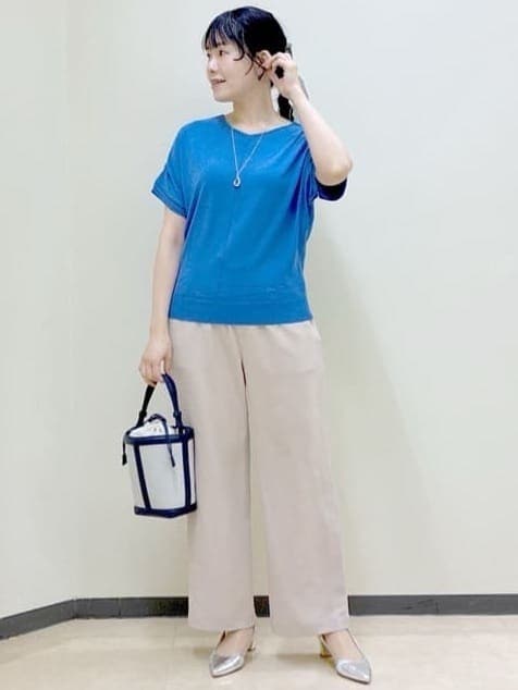 ベージュ系のその他パンツ、ブルー系のニット/セーター、ブルー系のショルダーバッグを着用したレディースの春コーディネートの6枚目の写真